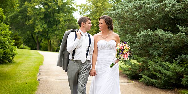 Katie and Jason Kammerdiener walking in Klehm Arboretum on their wedding day