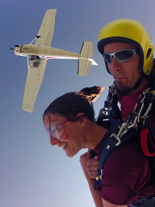 Katie and instructor in free fall with plane visible above